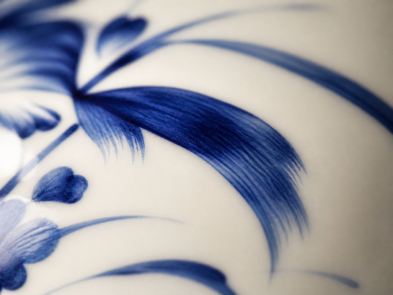 Macro view of hand-painted cobalt blue brushwork on white Japanese porcelain