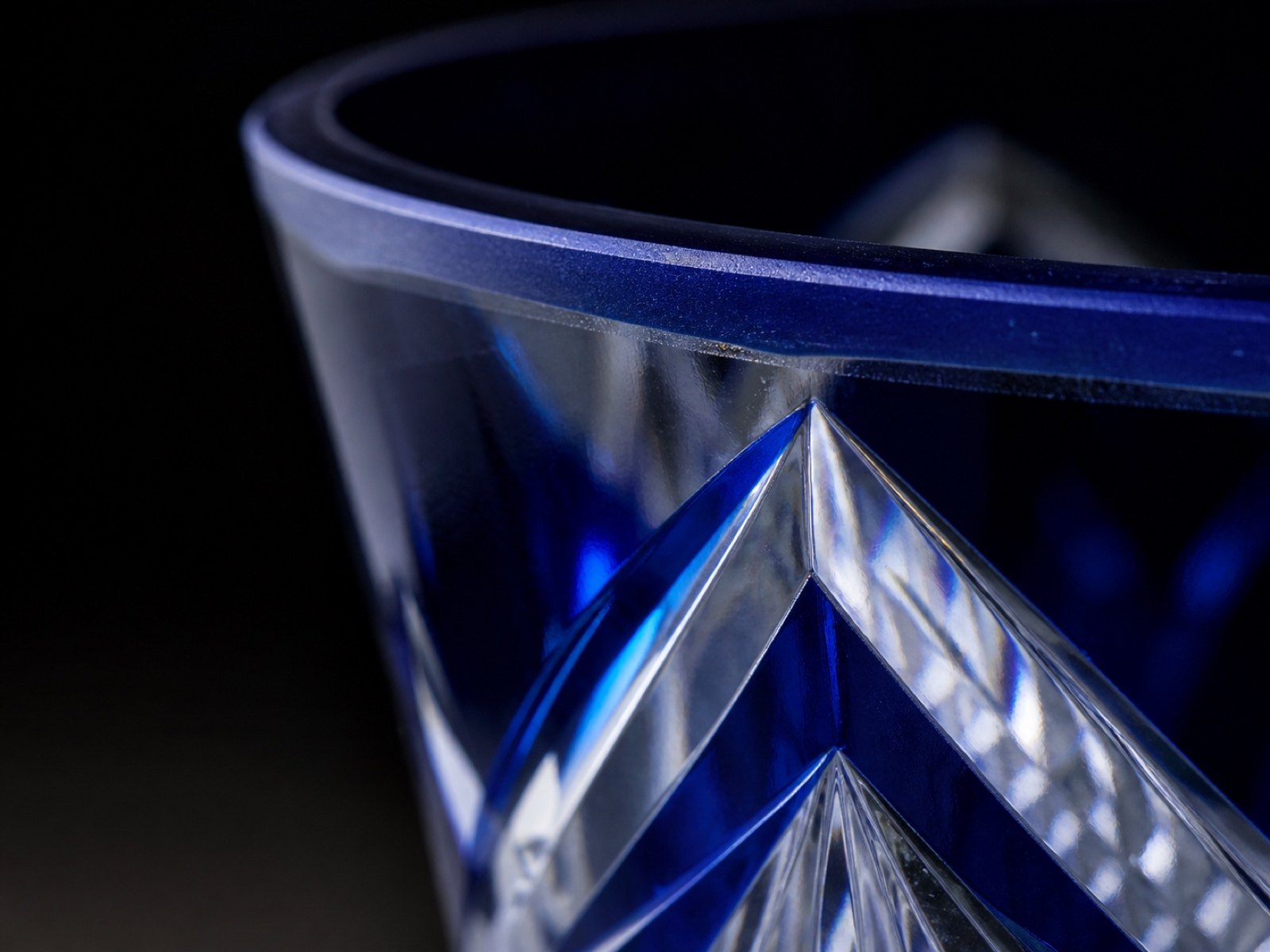 Macro view of the cut edge of a cobalt blue overlay glass, showing the thin colored layer over clear crystal